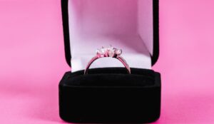 porta-joias de veludo proto, com anel prata e fundo rosa