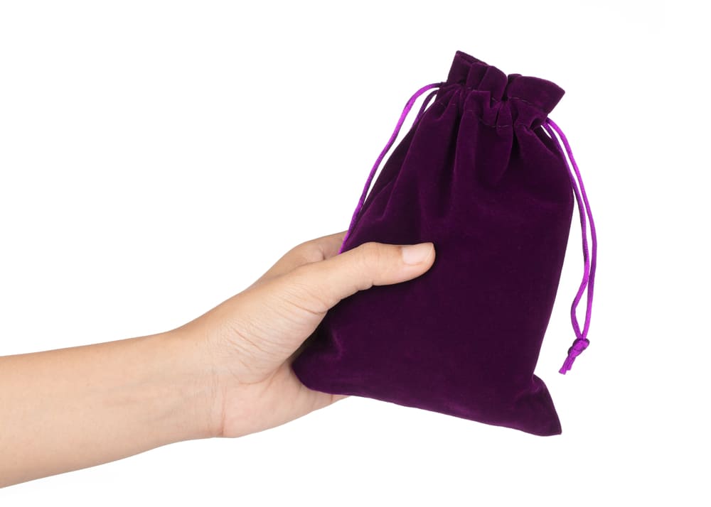 Saquinhos para semijoias personalizados da cor púrpura com uma pessoa segurando